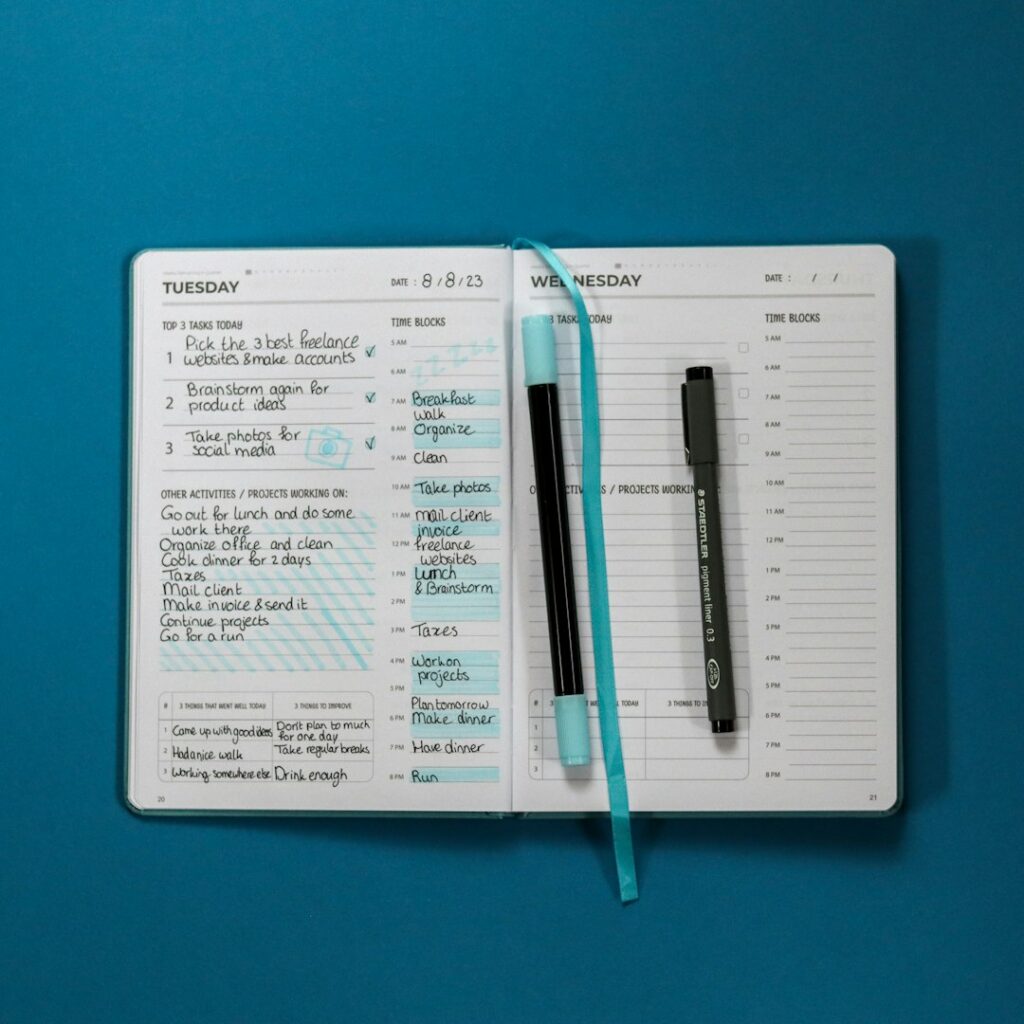 Planner notebook and pen on a desk representing the Daily Focus and Priorities Planner