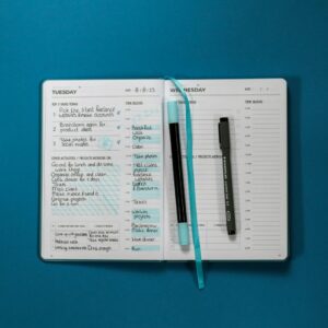 Planner notebook and pen on a desk representing the Daily Focus and Priorities Planner